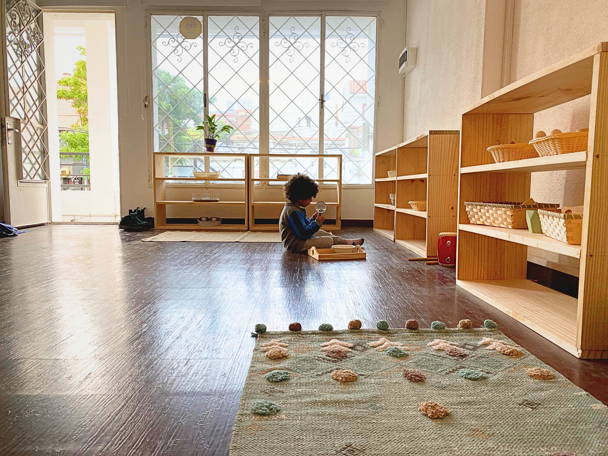 Un niño explorando con una lupa en el primer ambiente de D’amore, sin mostrar su rostro