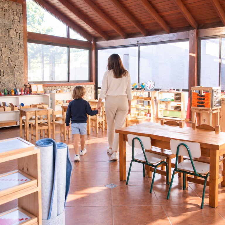 Niño y persona adulta de la mano en el ambiente de D’amore, vistos de espaldas